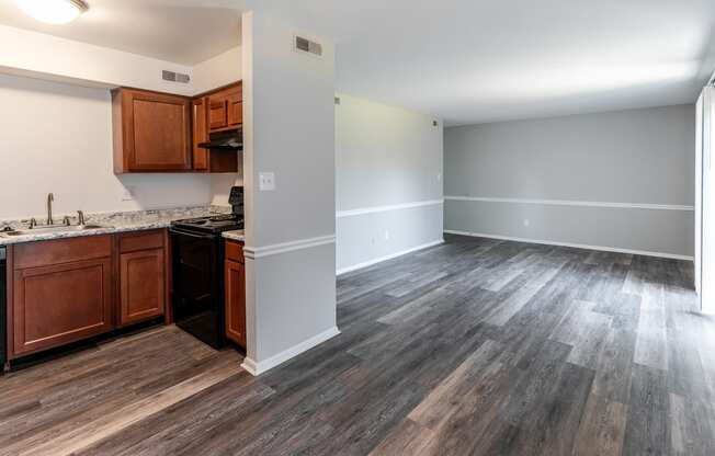 an empty kitchen and living room with wood flooring