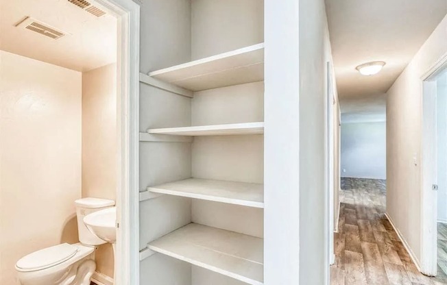 a bathroom with a toilet and some shelves in it at Gates of West Bay, Norfolk, VA 23503