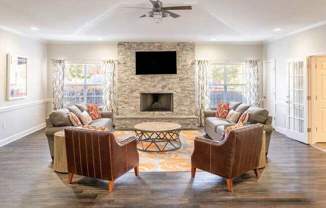 A living room with a fireplace and two chairs.