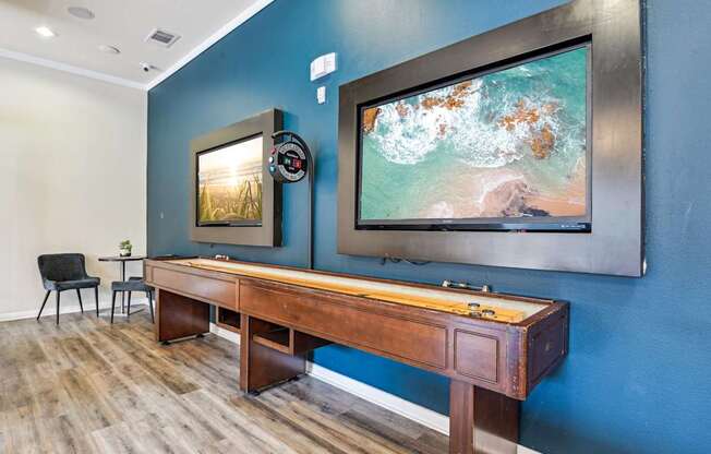A room with a blue wall and a wooden desk with a chair.