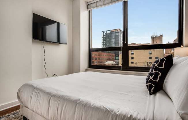 A bedroom with a large bed and a flat screen TV mounted on the wall.