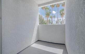 a view of palm trees from a window in a white room at Warner Center Townhomes, California
