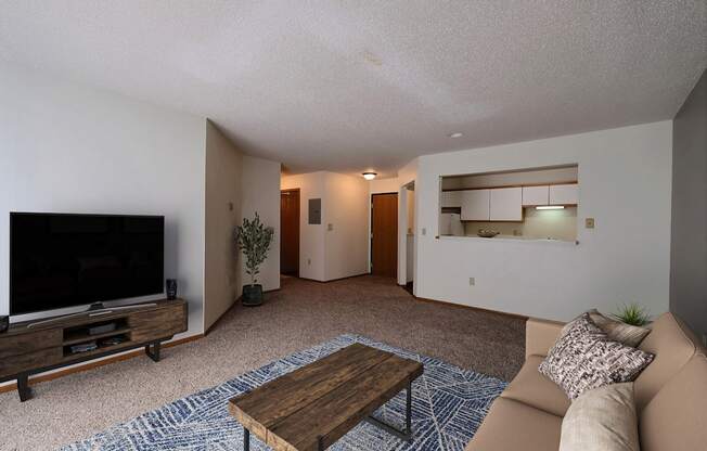 Living room with a couch and a coffee table and a tv at Park Place Apartments in ND