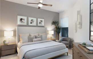 A bedroom with a large bed, a ceiling fan, and a nightstand with a lamp.