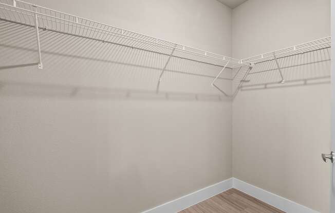 our spacious closets in the living room of a home with white walls and shelves
