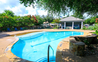 a swimming pool with a house in the background