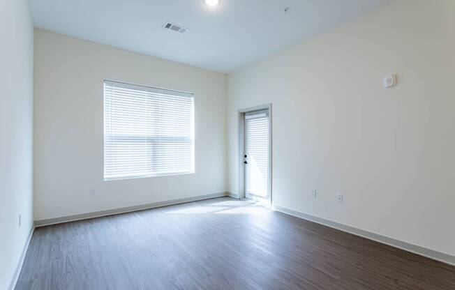 A room with a window and wooden flooring.