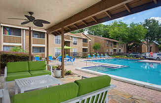 A patio with a pool and a ceiling fan.