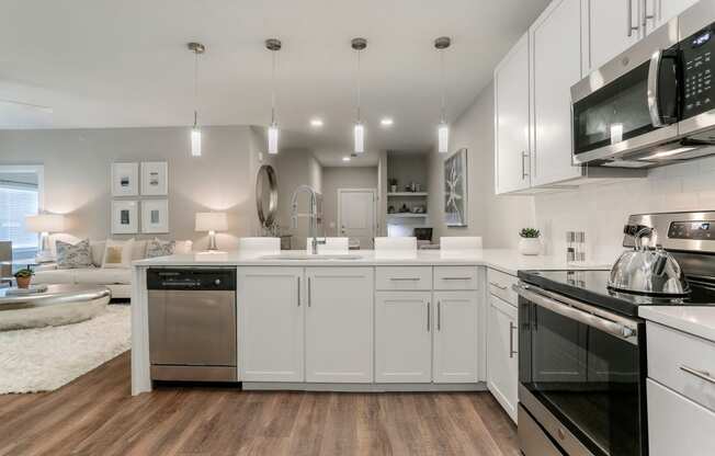 a spacious kitchen with white cabinets and stainless steel appliances