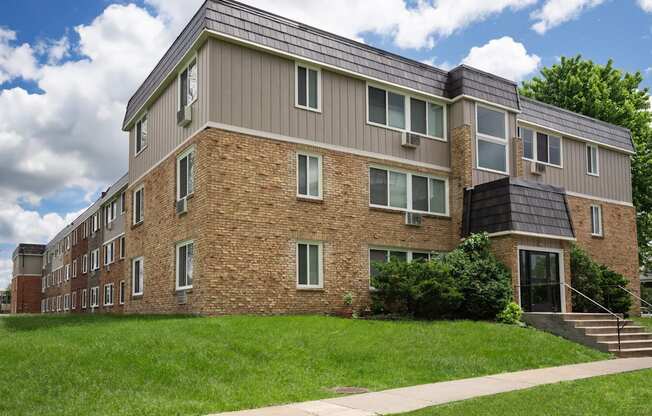 a brick apartment building with a solar roof on top of it. Fridley, MN Georgetown on the River Apartments