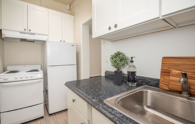 a kitchen with white appliances and granite counter tops and a sink