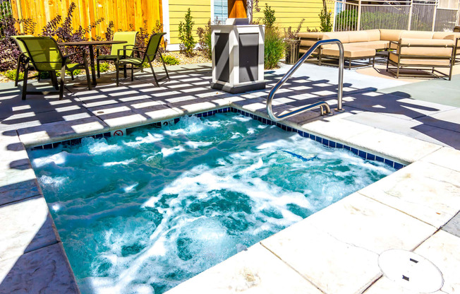 a hot tub in a pool next to a patio with furniture at Skyview Apartments, Colorado