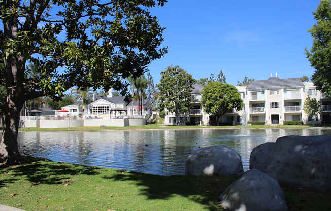 A serene lake surrounded by trees and houses.