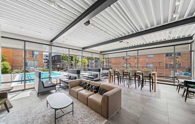 A modern living room with a pool outside the window.