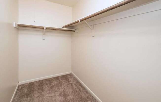 an empty room with a wall hung closet and a carpet