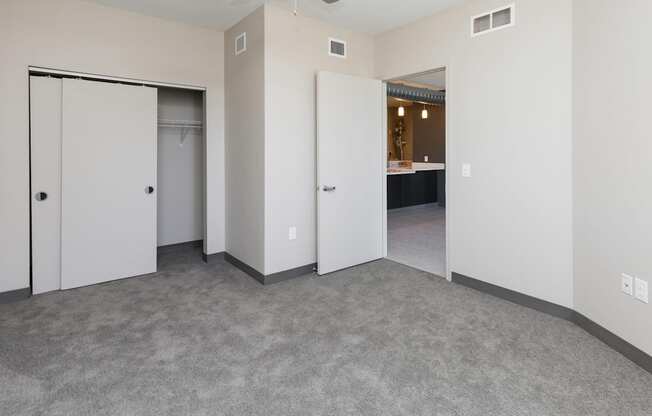 Bright, vacant bedroom with neutral walls and carpet flooring.