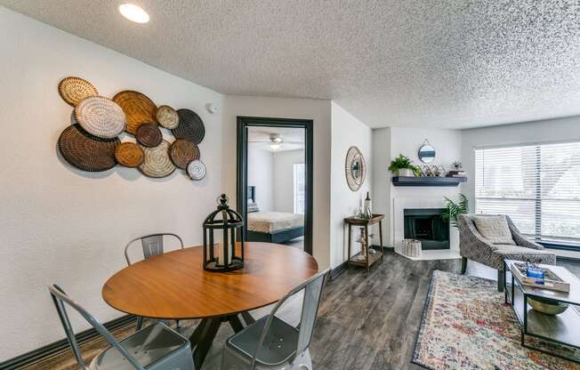 a living room with a dining room table and a fireplace