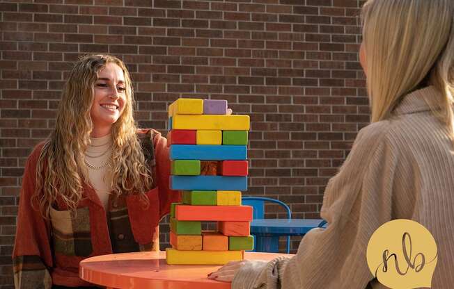 A woman is holding a stack of colorful blocks.