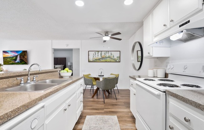 a kitchen and dining room with white cabinets and white appliances