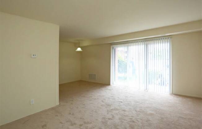 an empty living room with a sliding glass door to a patio at Gates of West Bay, Virginia