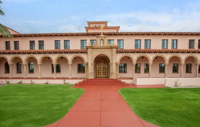 A large building with a red walkway leading to the entrance.