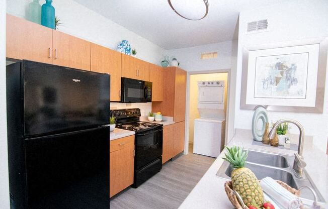 a kitchen with a black refrigerator and a sink