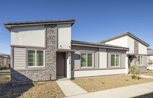 a house with a sidewalk in front of it at Grandstone at Sunrise, Peoria, AZ