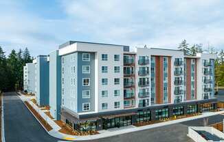 Complex with Parking Lot Access, Tall Trees, and Blue Skies at QUINN BY VINTAGE, Shoreline, WA