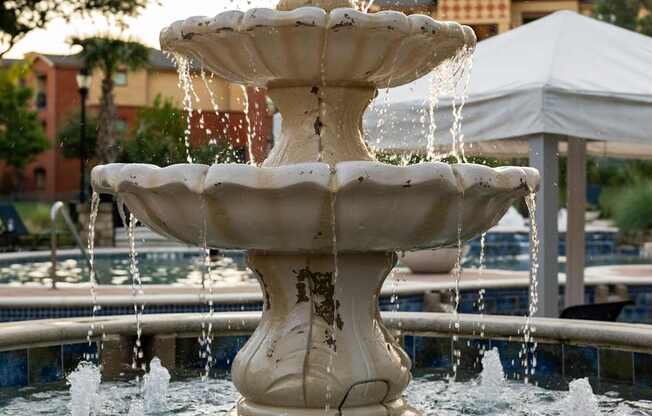 A white fountain with water spraying out of it.