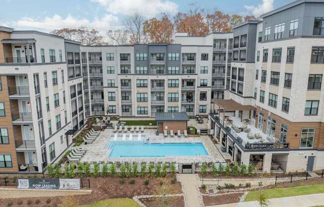 A large apartment complex with a pool in the middle.