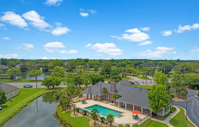 an aerial view of a house with a pool and a lake