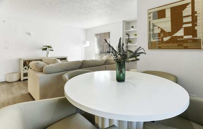 a living room with couches and a table and a vase of flowers