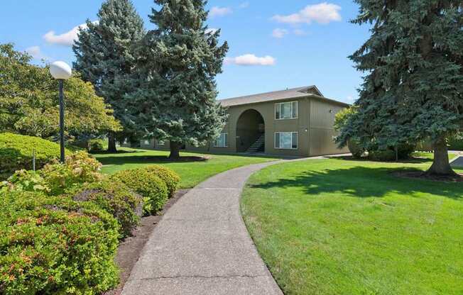 A pathway leads to a building with a green lawn on either side.