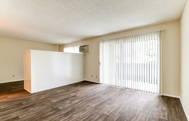 the spacious living room and dining room of an apartment