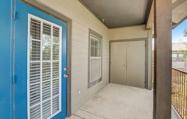 A blue door with white window blinds is on the left.