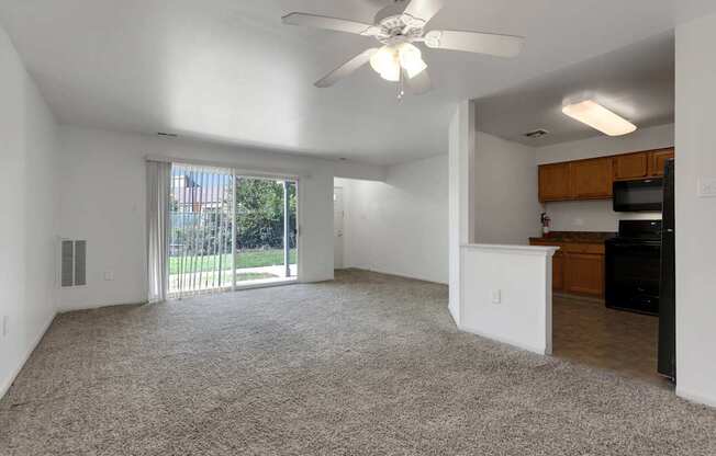 an empty living room and kitchen with a sliding glass door