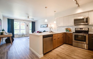 Kitchen with Wood Inspired Floor, Oven, Stove, Microwave, Dishwasher and View of Living Room