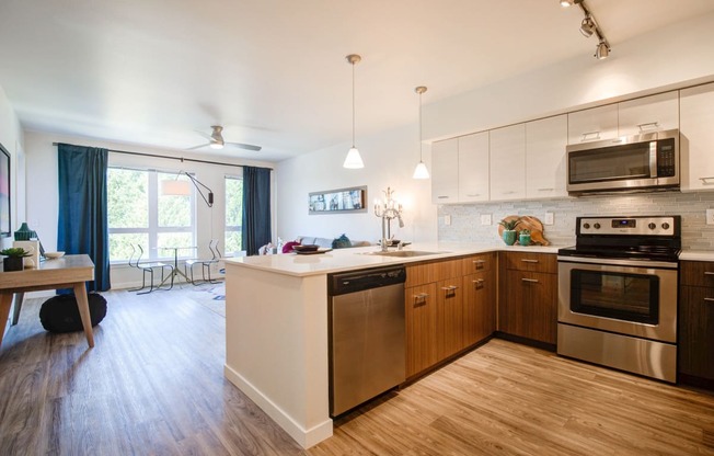 Kitchen with Wood Inspired Floor, Oven, Stove, Microwave, Dishwasher and View of Living Room