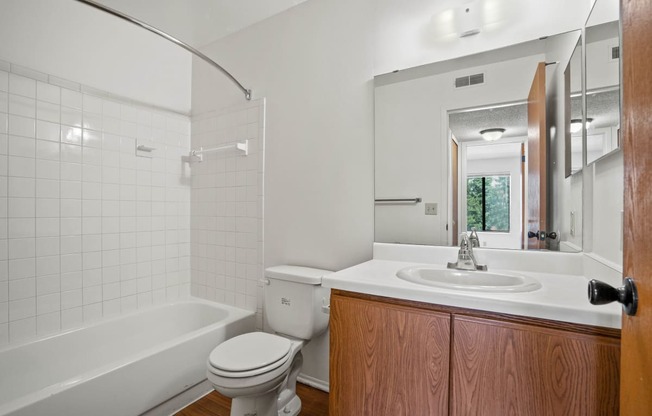 a bathroom with a toilet sink and bathtub at Beacon Hill and Great Oaks Apartments, Illinois, 61109