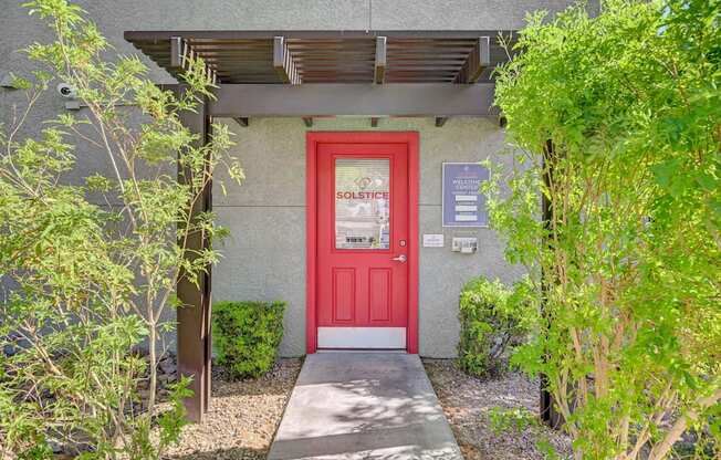 A red door with a sign that says "SOLSTICE" on it.