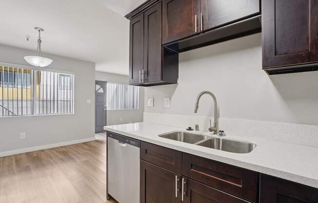 A kitchen with a white counter top and brown cabinets.