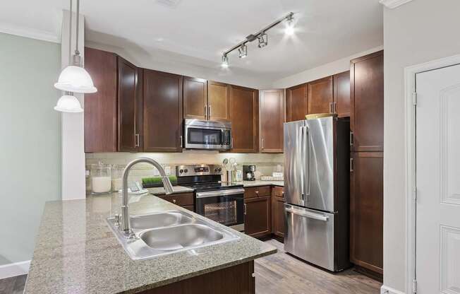 A kitchen with brown cabinets and a stainless steel refrigerator.