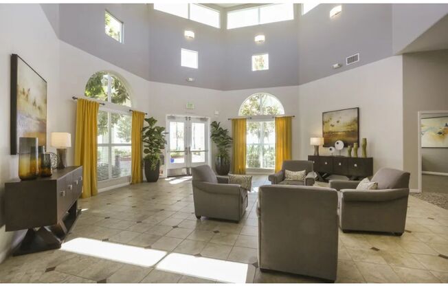 a large living room with couches and chairs  at Tesoro Senior Apartments, Porter Ranch, CA, 91326