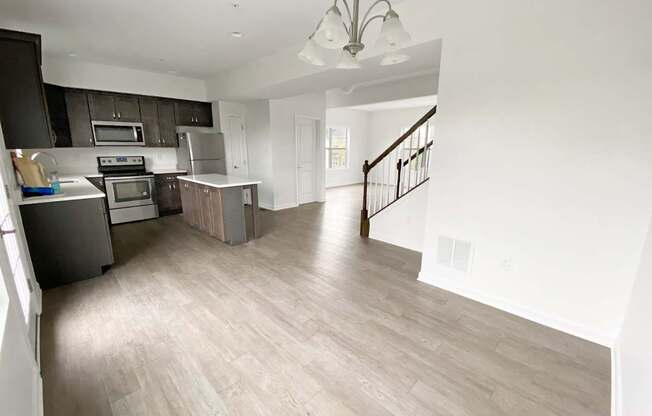 A spacious kitchen with a staircase leading to the upper floor.