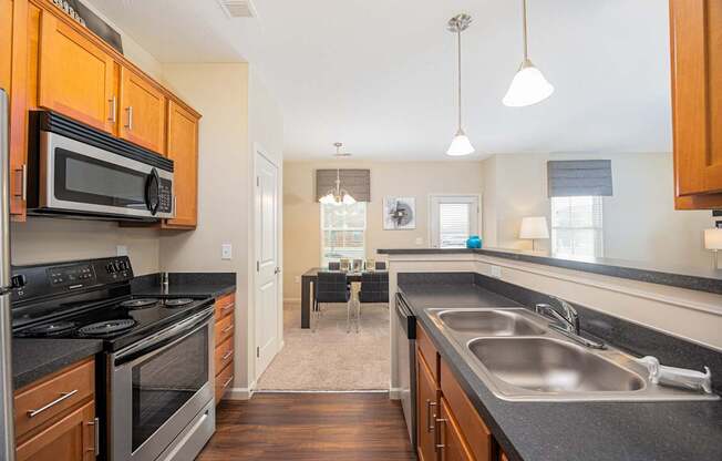 A kitchen with wooden cabinets and black countertops.