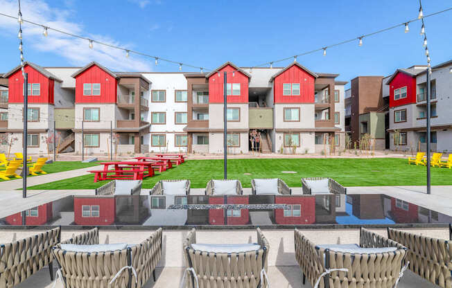 A row of red and white buildings with a lawn in front.