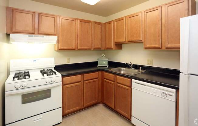 A kitchen with wooden cabinets and white appliances.
