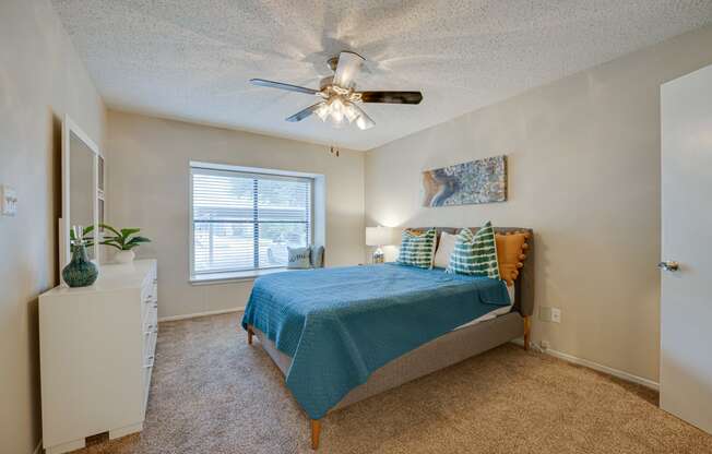 a bedroom with a bed and a ceiling fan