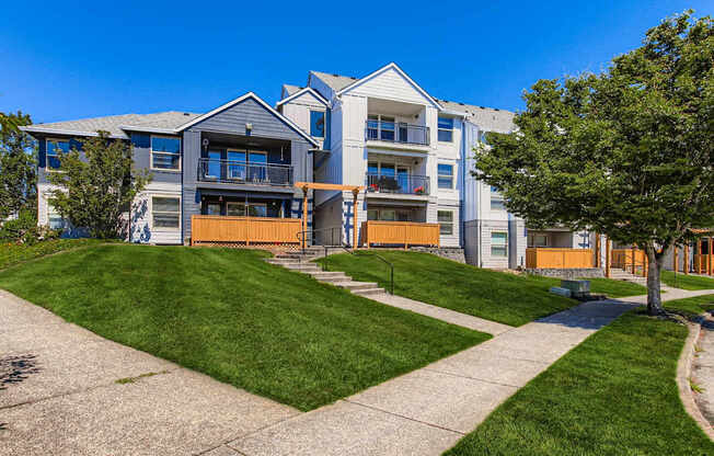 A modern apartment building with a green lawn in front.