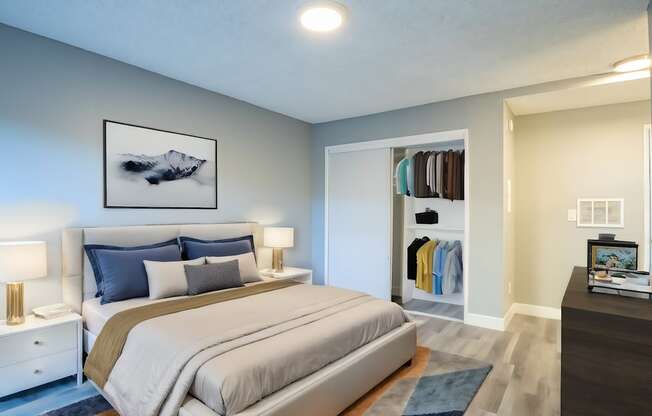 A bedroom with a large bed and a painting above it.